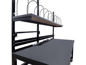 Close-up of a packing workbench with integrated power strip, cable management, and upper storage shelf with dividers.